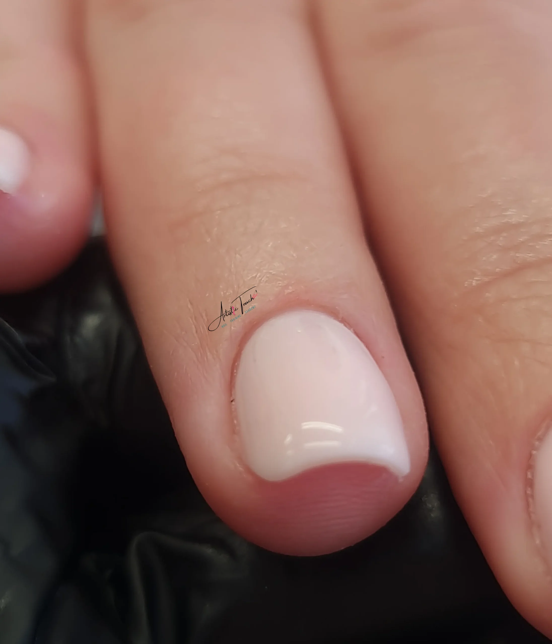 Close-up of professional BIAB application showing clean cuticle work and smooth finish by Artistic Touch Academy