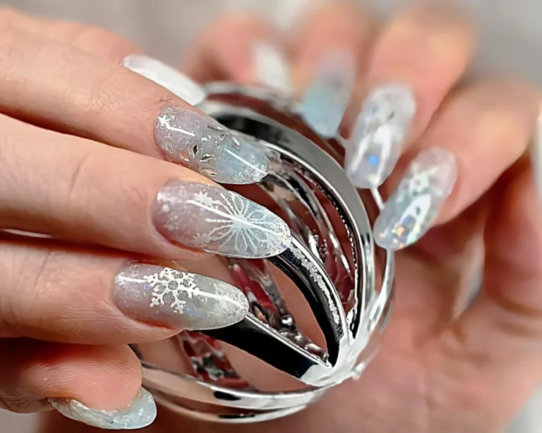 Close-up of frosty snowflake nails created with sandwich dual forms technique showing chrome ombre, 3D snowflakes, chameleon flakes and crystal ball prop