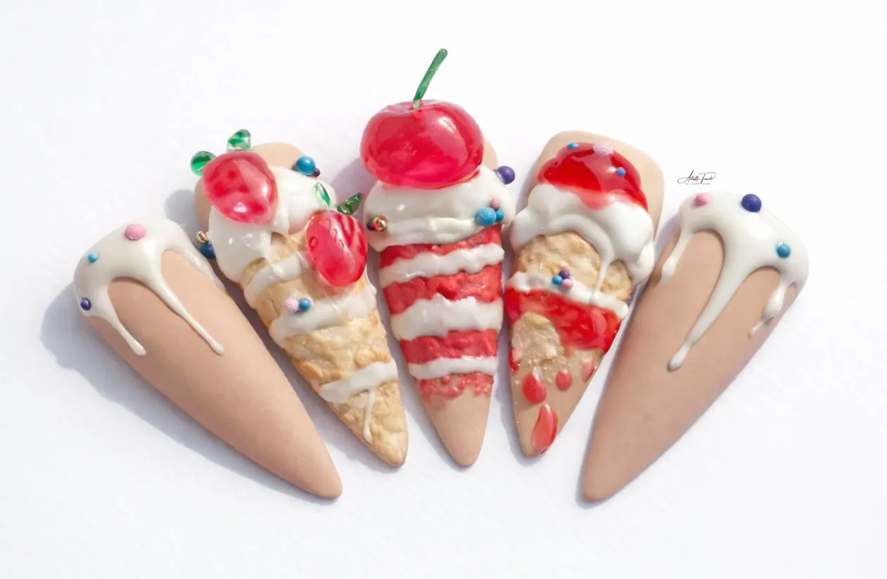 Close-up detail of 3D cake nail art showing dripping frosting technique and dimensional fruit decoration