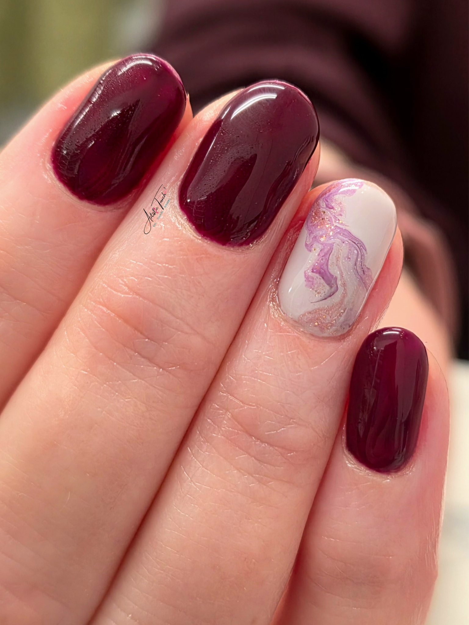 Burgundy manicure with a marbled accent nail created by Radina Ignatova
